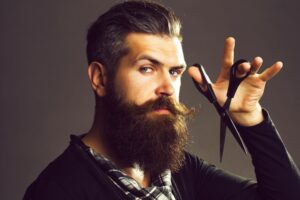 Bottle of premium beard oil with natural ingredients on a wooden table.